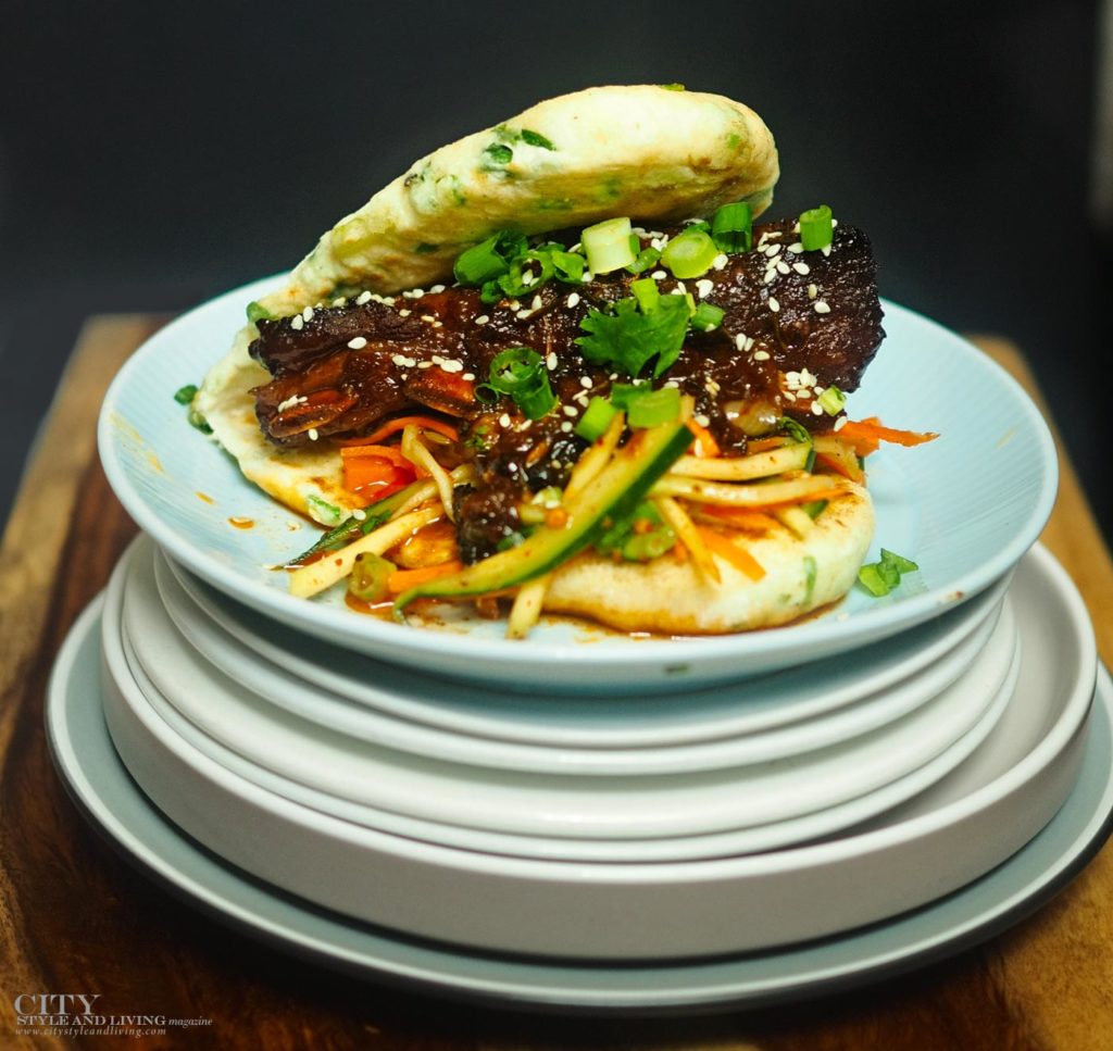 City Style and Living Fall 2023 Korean Braised Lamb Bao with Pickled Slaw plated on wooden board
