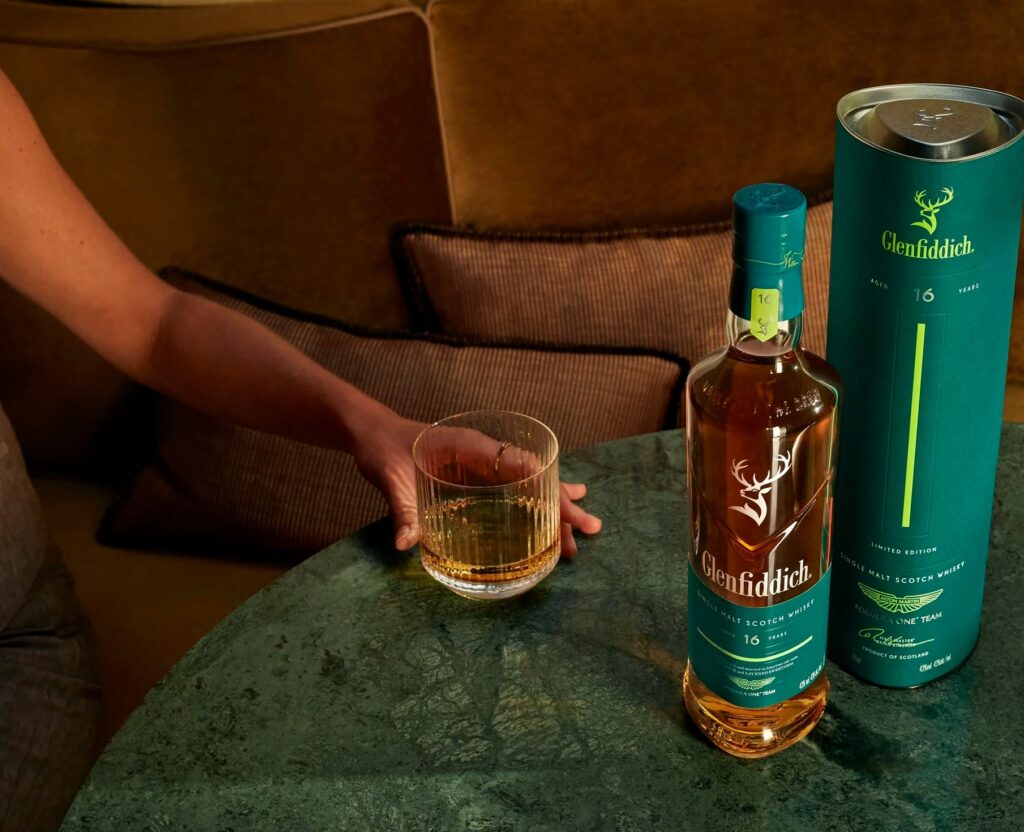 Glenfiddich & Aston Martin Formula One™ Team 16 Year Old Limited Edition holding glass